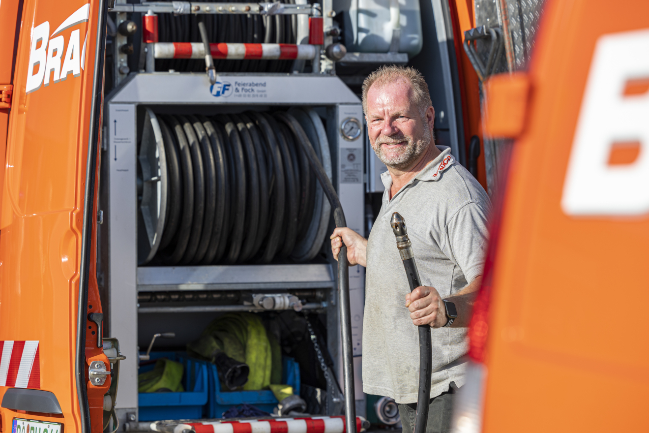 BrauCo Mitarbeiter rollt einen Schlauch ab